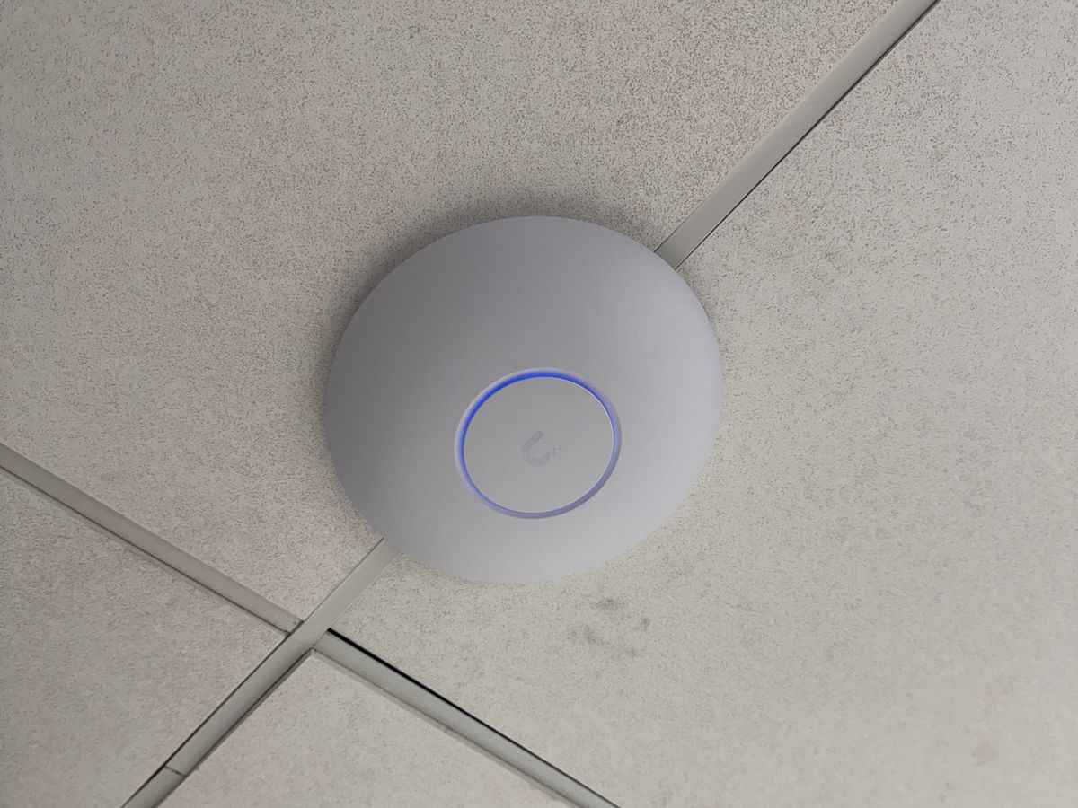 UniFi wireless access point installed on an office ceiling